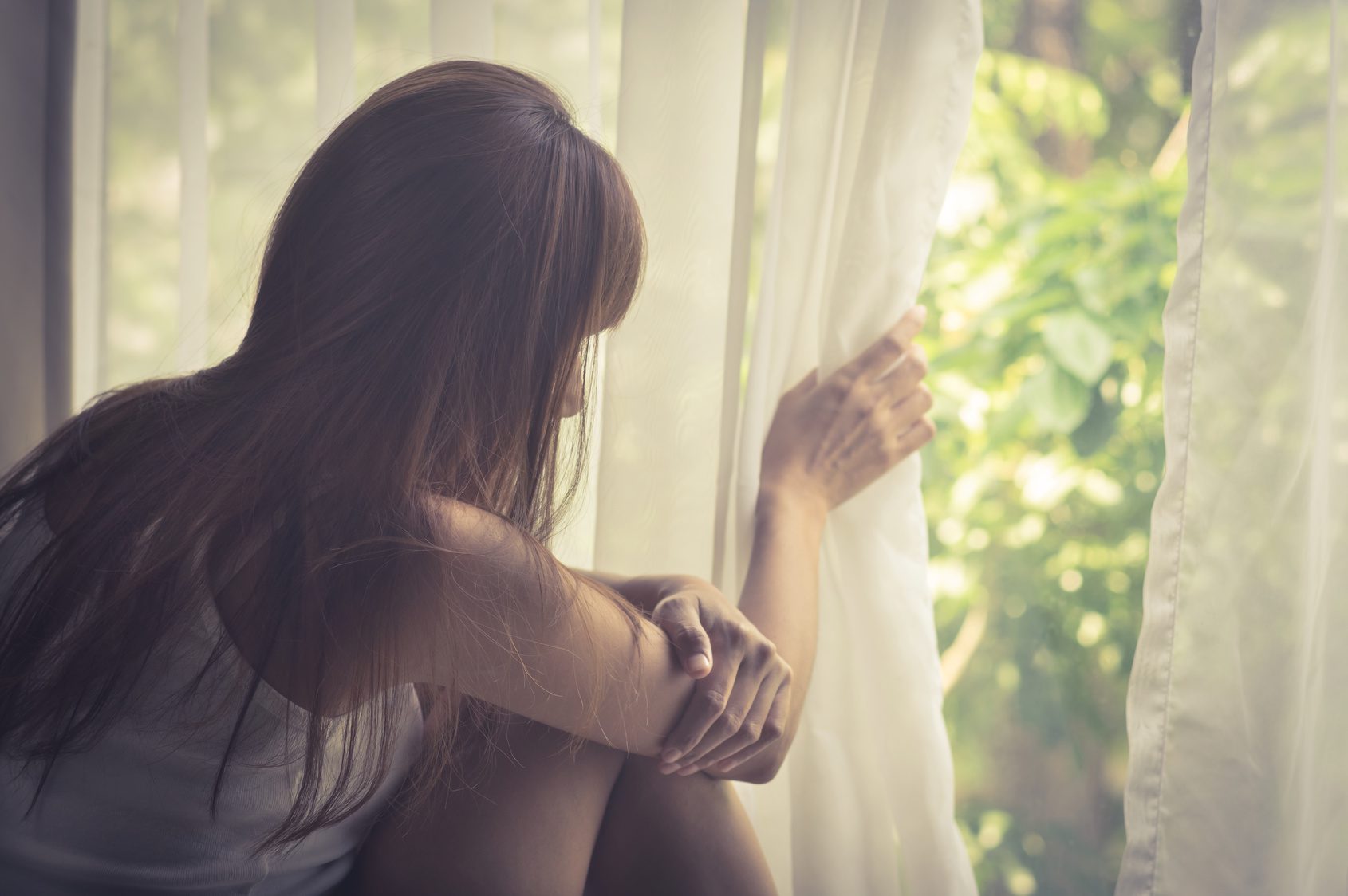 Sad girl looking out of window